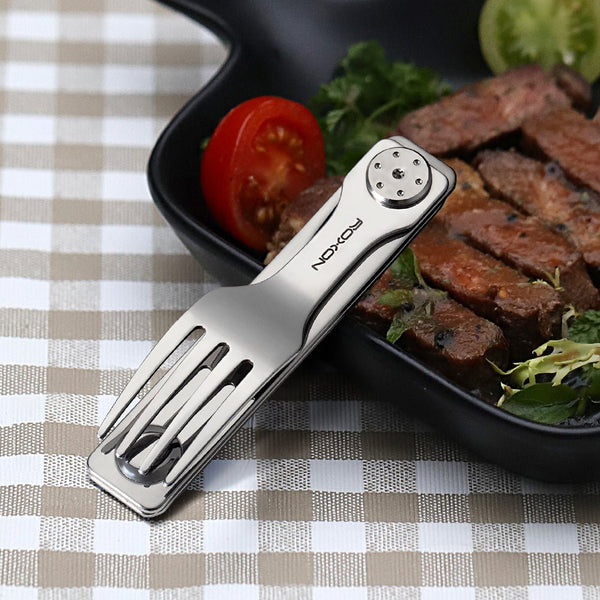 Multifunctional outdoor fork on a checkered tablecloth with a meal in the background
