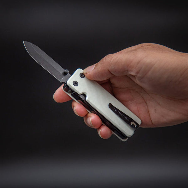 Hand holding a folding knife with a dark background