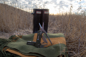 Flex Shears and Mini Flex Companion on a blanket out on a trail with a background of boots.