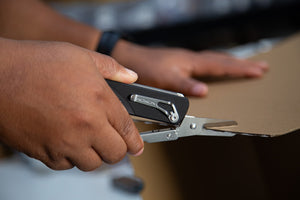 Flex Shears in hands cutting through a cardboard