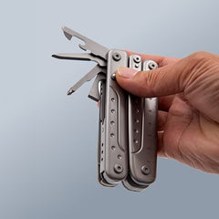 Hand holding a ROXON multitool with several tools partially extended, demonstrating compact functionality and ergonomic design.