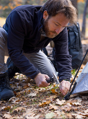 Man setting up a tent in a forest