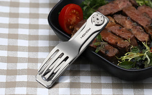 Metallic kitchen tool on a checkered tablecloth with a plate of food in the background