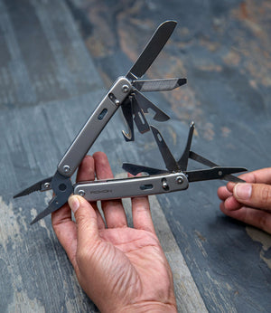 Multi-tool being held by a person with a textured blue background