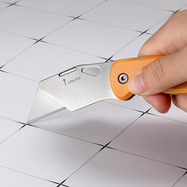Hand holding a utility knife over a tiled floor