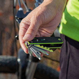 Person holding a multi-tool with bicycles in the background