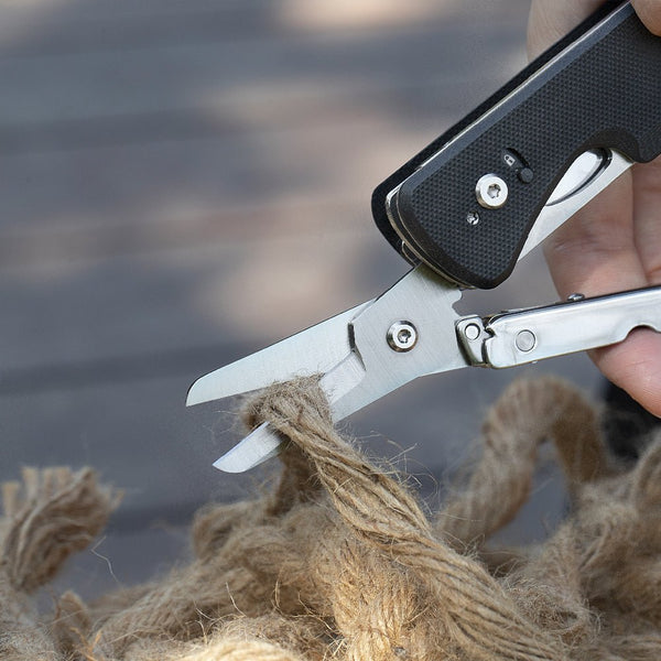 Folding shears cutting through twine with a blurred background