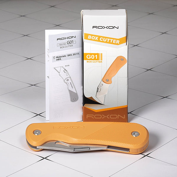 Orange Roxon box cutter with packaging on a tiled floor