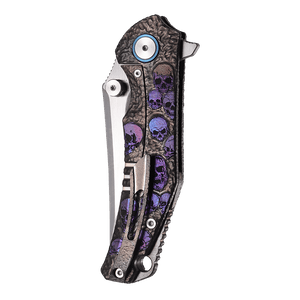 Folding knife with skull design handle on a white background