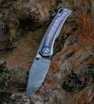 Folding knife with a decorative handle on a textured wooden background