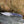 Folding knife with a decorative blade and handle on a rocky surface