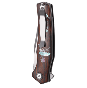 Wooden-handled folding knife with floral designs on a white background