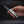 Hand holding a folding knife with a dark background