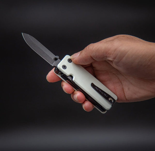 Hand holding a folding knife with a dark background