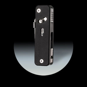 Black modular multi tool with textured surface on a reflective black and gray background